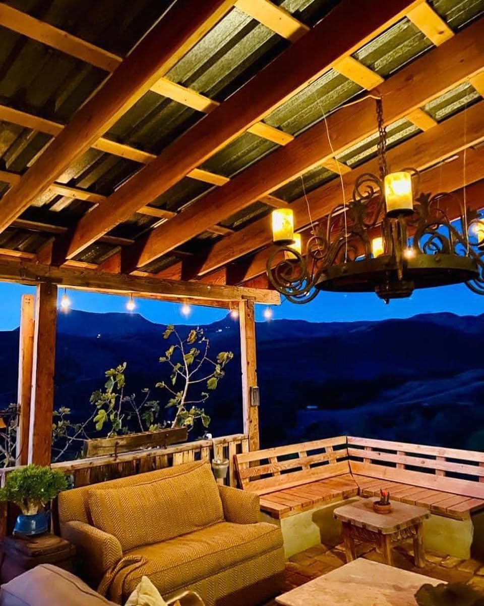 Terraza de madera al atardecer con vista al valle